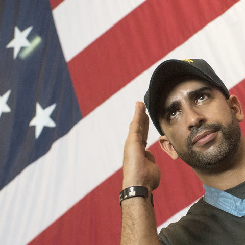 Flo Groberg, U.S. Army veteran and Medal of Honor recipient, saluting in front of an American flag